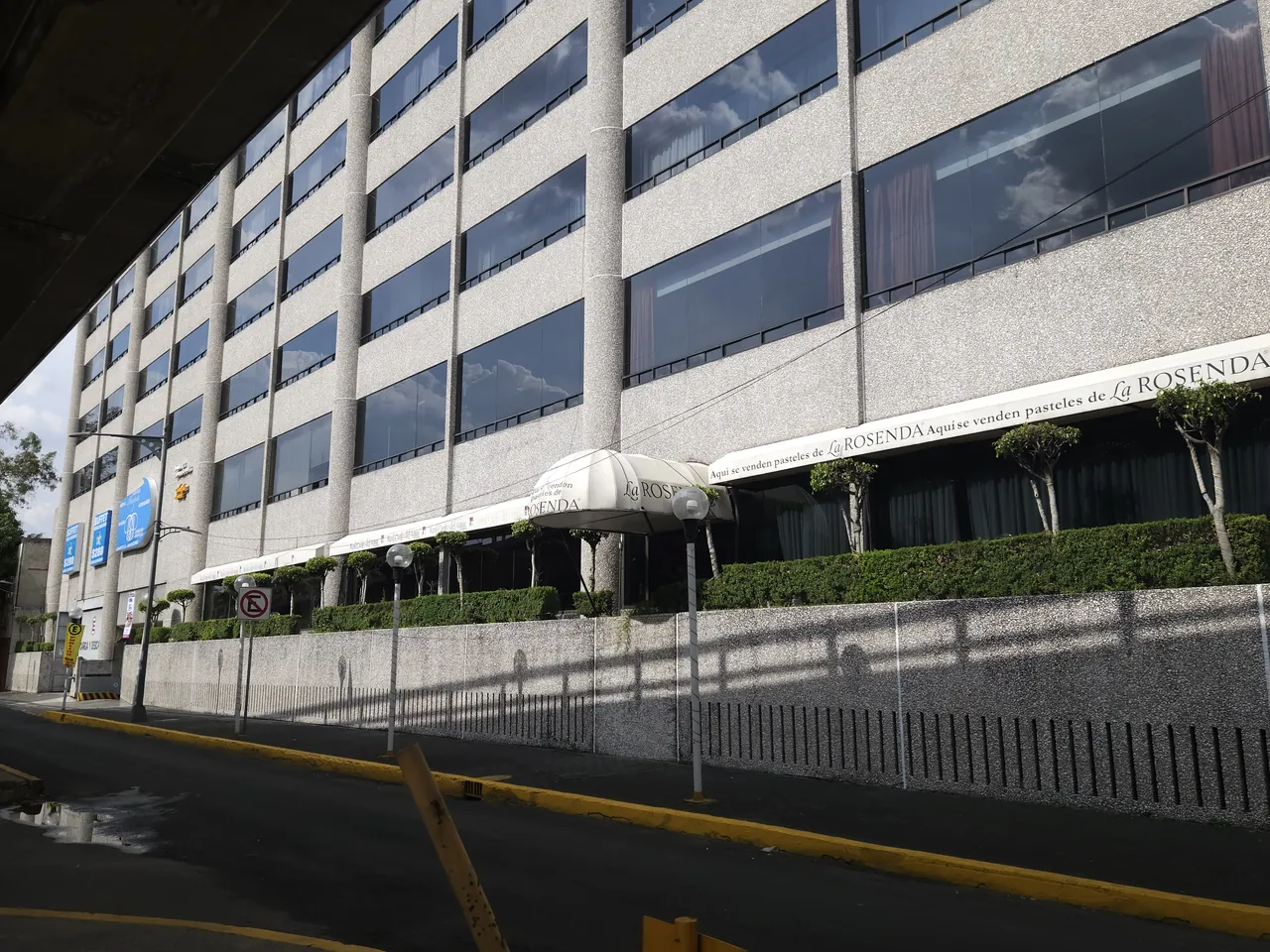 Fachada del Hotel Real del Sur a lo largo de Avenida División del Norte, con la terraza de la pastelería bajo su toldo y el seto de la banqueta