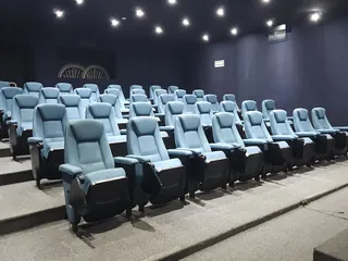 Las butacas del auditorio vistas desde el pasillo, con la tarima delante y el muro oscuro al fondo