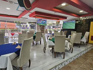 Mesas con manteles azules y blancos, hacia los ventanales