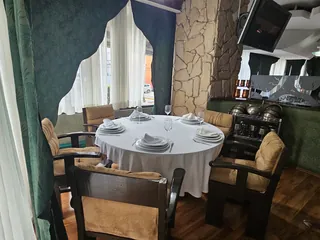 Mesa junto al muro de piedra, con las copas servidas y la cortina blanca detrás