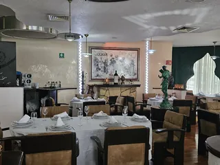 Mesas del salón vestidas y listas, con la escultura de bronce a un lado