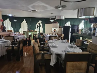 Vista general del salón: suelo de madera, ventanas ojivales y las mesas puestas