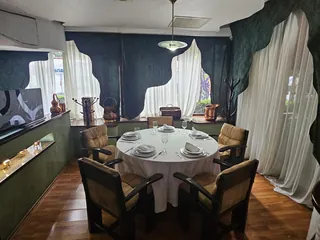Mesa para seis en el rincón verde, con el aparador de madera detrás