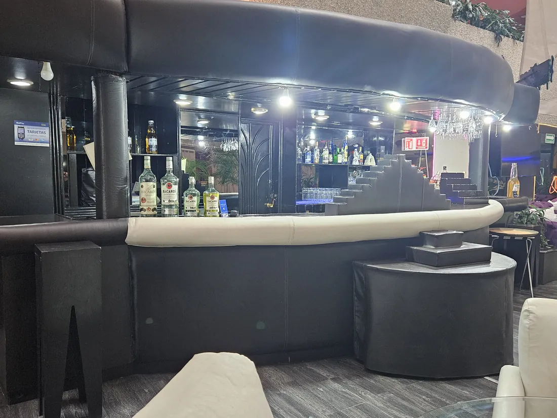 Barra del Kon Tiki, con las botellas iluminadas al fondo y el pasamanos acolchado en primer plano