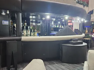Barra del Kon Tiki, con las botellas iluminadas al fondo y el pasamanos acolchado en primer plano